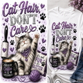 A graphic design for a t-shirt featuring a fluffy gray tabby cat wearing a purple bandana, with the text 'Cat Hair, DON'T Care' in purple glitter lettering. The design includes a purple rolling pin, a black coffee mug with 'FUELED BY Coffee & CAT CUDDLES' text, a purple ball of yarn, and a small sign reading 'it's not Fun it's GLITTER'.