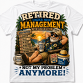 A white short-sleeve graphic t-shirt featuring a colorful cartoon illustration of a retired man relaxing by a beach, with text reading 'RETired UNDER NEW MANAGEMENT' and 'NOT MY PROBLEM ANYMORE!'.