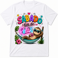 White short-sleeve crewneck t-shirt featuring a colorful graphic print of a cartoon sloth wearing sunglasses and relaxing in a hammock with the Spanish text 'SABADO dia de Relax' in vibrant, playful lettering.