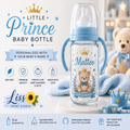 Personalized baby bottle with a light blue collar and handles, featuring a printed teddy bear, crown, and the name 'Matteo' on a white background with promotional text and a teddy bear plush.