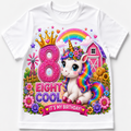 A white short-sleeve kids' t-shirt featuring a vibrant, colorful graphic design for an 8th birthday. The design includes a cute cartoon unicorn with a rainbow mane, a pink glittery number 8 with a gold crown, the text 'EIGHT COOL', and 'IT'S MY BIRTHDAY!' on a pink banner, set against a background of flowers, a barn, and a rainbow.