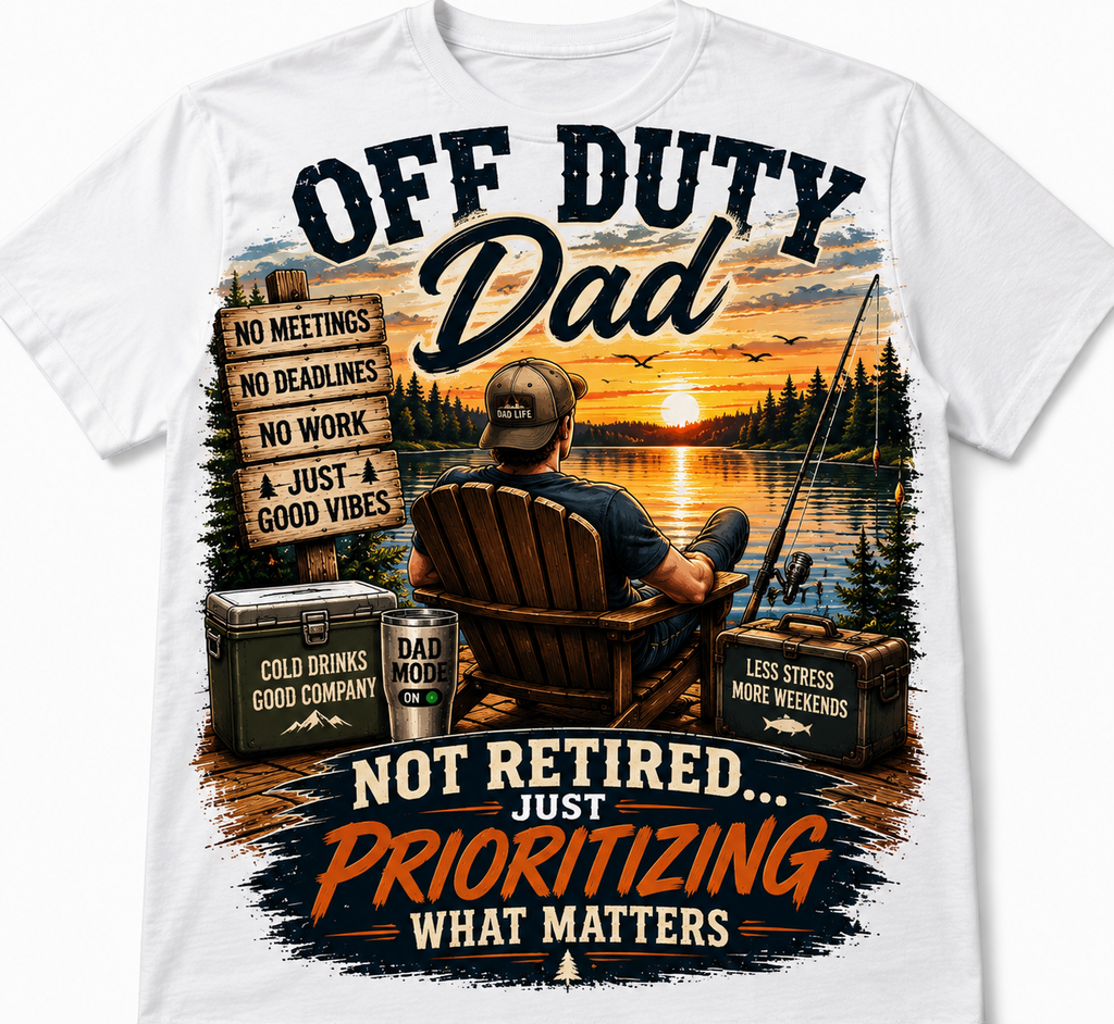 White short-sleeve crewneck t-shirt featuring a large, colorful graphic print on the front. The graphic depicts a man in an Adirondack chair fishing by a lake at sunset, with humorous text overlays like 'OFF DUTY Dad' and 'NOT RETIRED.
