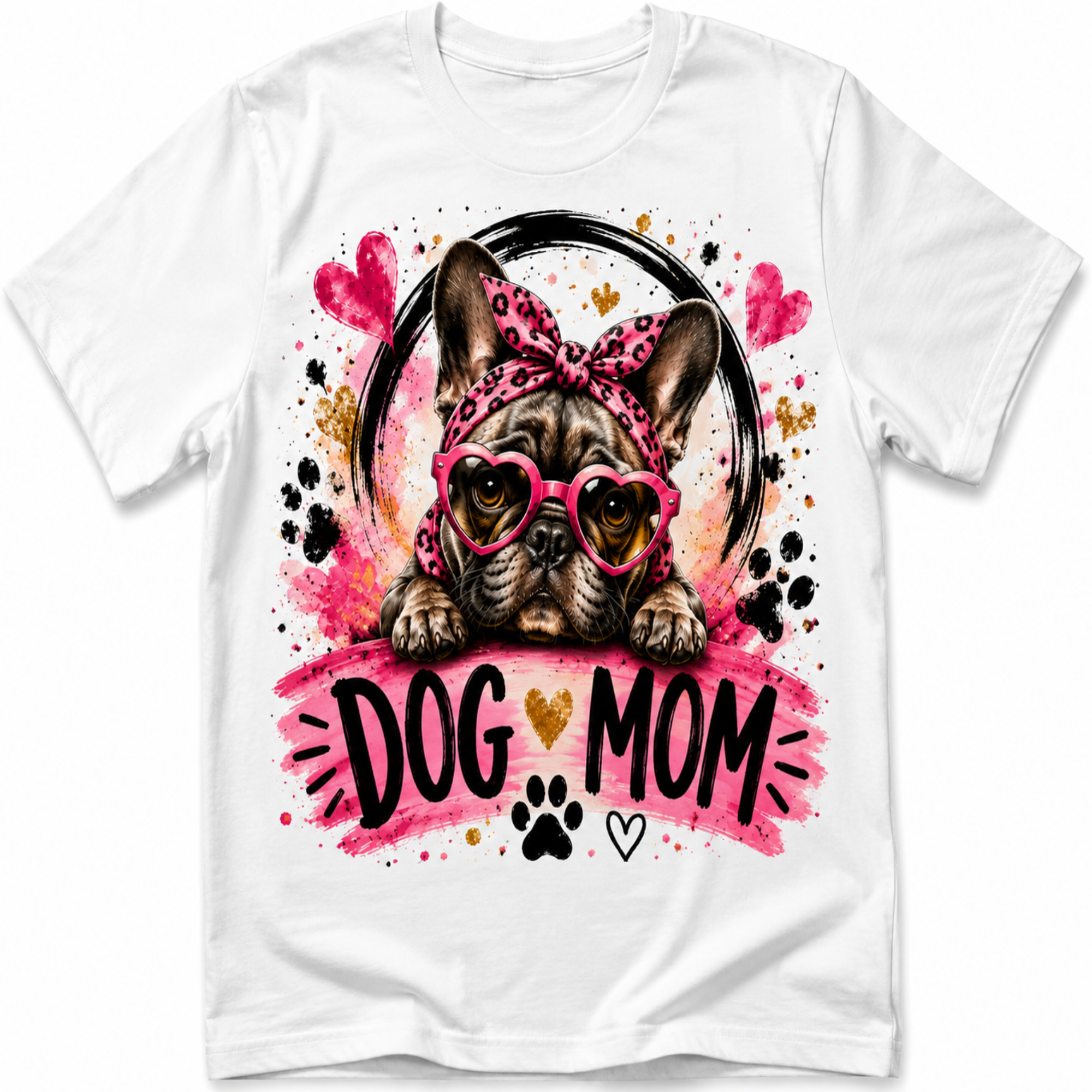 White short-sleeve crewneck t-shirt featuring a colorful graphic of a French Bulldog wearing pink heart-shaped sunglasses and a pink leopard-print headband, with the text 'DOG MOM' in black and gold on a pink watercolor background.