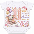 White short-sleeve baby bodysuit with a colorful 11-month birthday graphic featuring a teddy bear, balloons, stars, and the text 'Eleven Months of Love'.