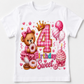 A white short-sleeve kids' t-shirt featuring a colorful '4th Birthday Sweet' graphic print with a teddy bear, donuts, balloons, a cupcake, and a crown.
