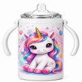 A white stainless steel baby tumbler with two side handles, featuring a colorful cartoon unicorn illustration on the front. The tumbler has a clear lid and is shown against a plain white background.