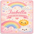 A personalized baby blanket or rug featuring a cute pastel design with two rainbows, smiling clouds, a sun, hearts, stars, and the name 'Isabella' with the phrase 'YOU ARE MY SUNSHINE' on a pink background.