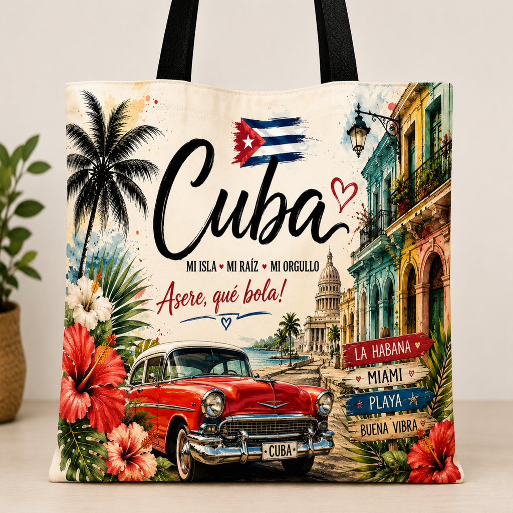 A canvas tote bag featuring a colorful Cuban-themed illustration with the word 'Cuba' in large script, a red classic car, tropical flowers, palm trees, and colonial-style buildings. The bag has black handles and is photographed against a light neutral background with a small plant partially visible on the left.