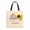 A cream-colored canvas tote bag with black handles, featuring a printed design of a yellow sunflower, pink hearts, and the text 'Liss PRINT STUDIO'.